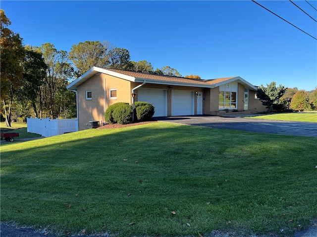 single story home featuring a front lawn and a garage