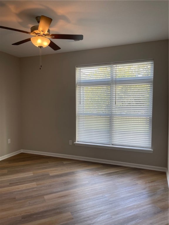 spare room featuring wood-type flooring and ceiling fan