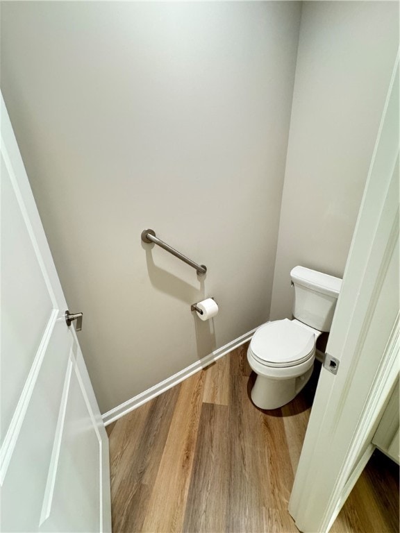 bathroom with hardwood / wood-style flooring and toilet