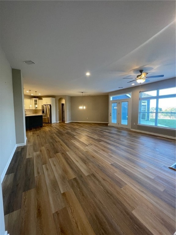 unfurnished living room featuring ceiling fan and dark hardwood / wood-style floors