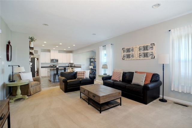 carpeted living room featuring sink