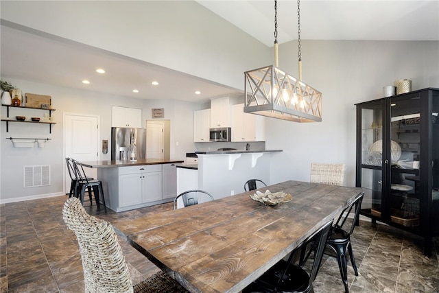 dining room with a notable chandelier and high vaulted ceiling