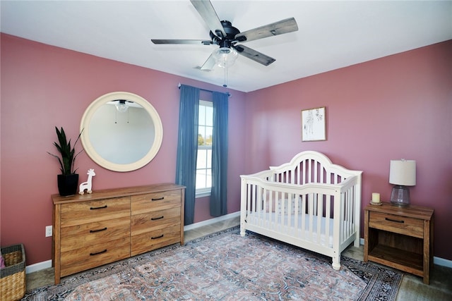 bedroom with ceiling fan and a crib