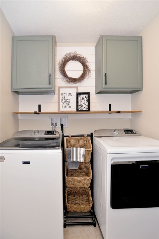 washroom featuring washing machine and dryer and cabinets