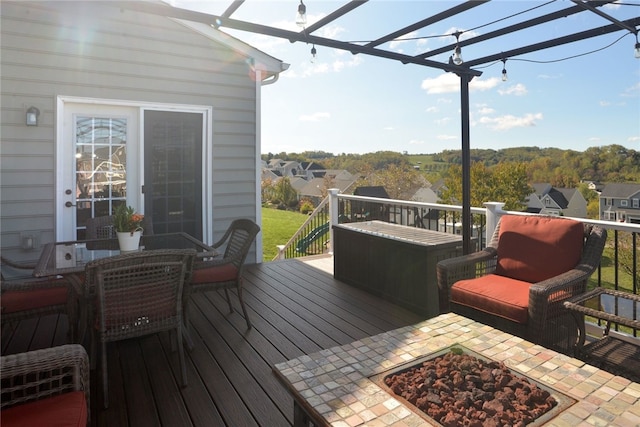 wooden deck featuring an outdoor fire pit and a pergola