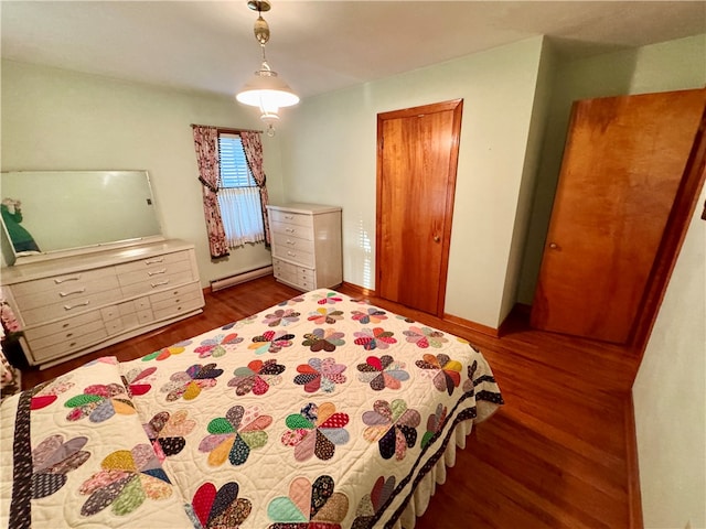 bedroom featuring dark hardwood / wood-style floors and a baseboard heating unit