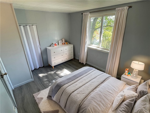 bedroom with dark wood-type flooring