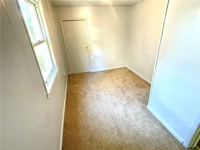 spare room featuring light colored carpet and plenty of natural light