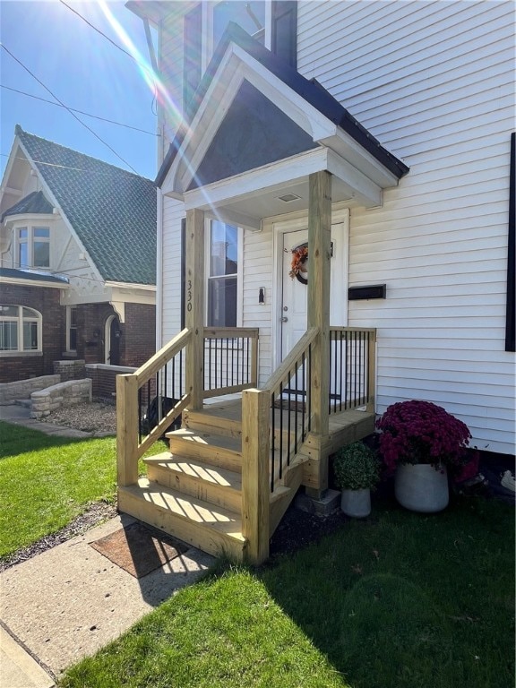 property entrance featuring a lawn