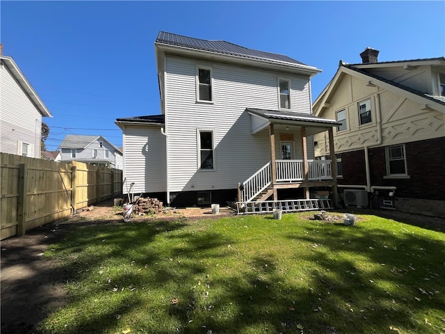 rear view of property featuring a yard