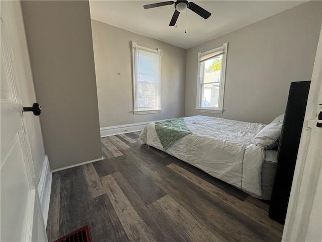 bedroom with dark hardwood / wood-style flooring and ceiling fan