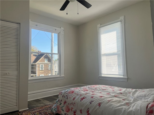 bedroom with dark hardwood / wood-style flooring, multiple windows, and ceiling fan