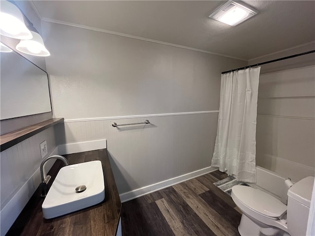 full bathroom featuring hardwood / wood-style flooring, toilet, ornamental molding, shower / tub combo with curtain, and vanity