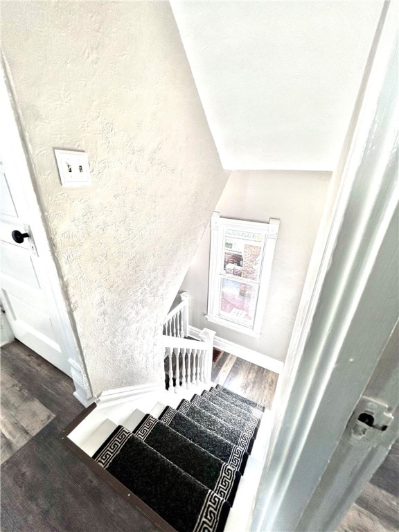 stairs featuring lofted ceiling and wood-type flooring