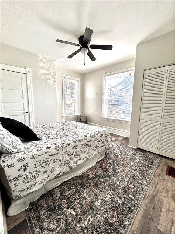 bedroom featuring dark wood-type flooring, ceiling fan, and a closet