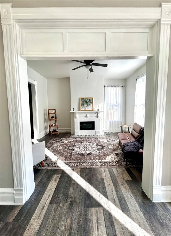 living room featuring ceiling fan and dark hardwood / wood-style flooring