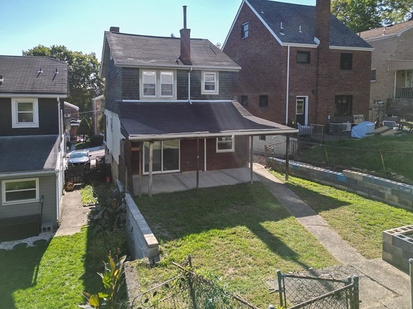 rear view of property with a yard and a patio area