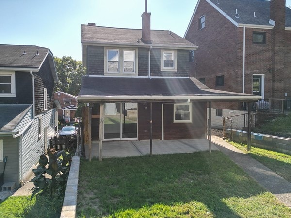 back of property featuring a patio and a lawn