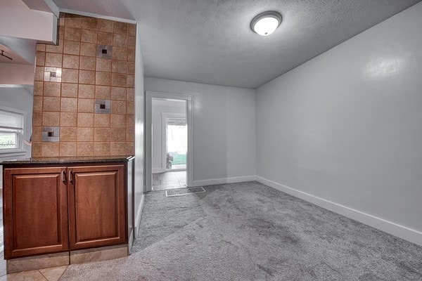 interior space with plenty of natural light, tile walls, and a textured ceiling