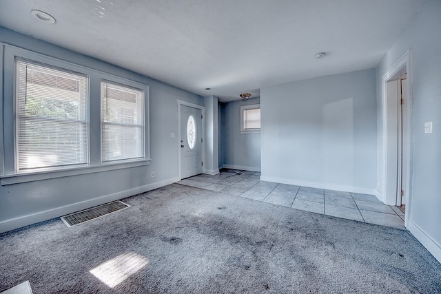 foyer entrance with a wealth of natural light and light carpet