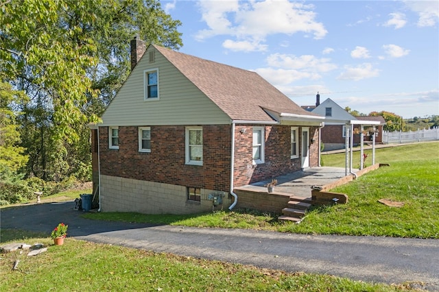 view of property exterior featuring a lawn and a patio area