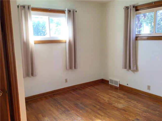 unfurnished room with dark wood-type flooring