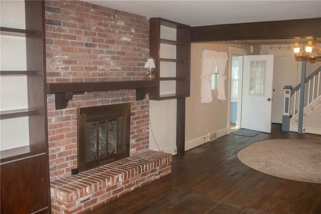 unfurnished living room with a brick fireplace and dark hardwood / wood-style flooring