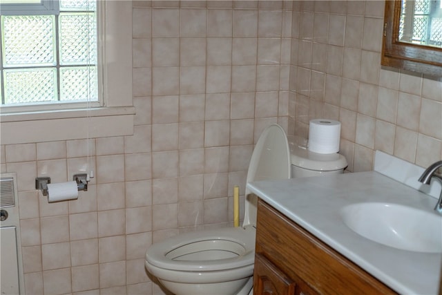 bathroom with vanity, tile walls, and toilet