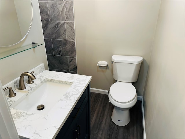 bathroom with hardwood / wood-style floors, vanity, and toilet