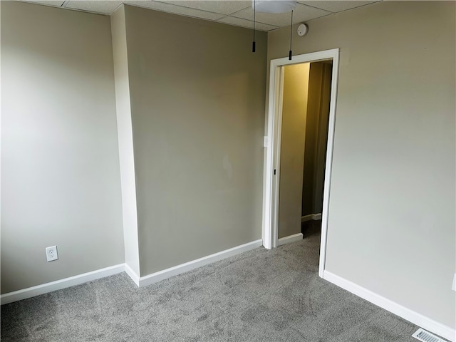 unfurnished room with carpet and a paneled ceiling