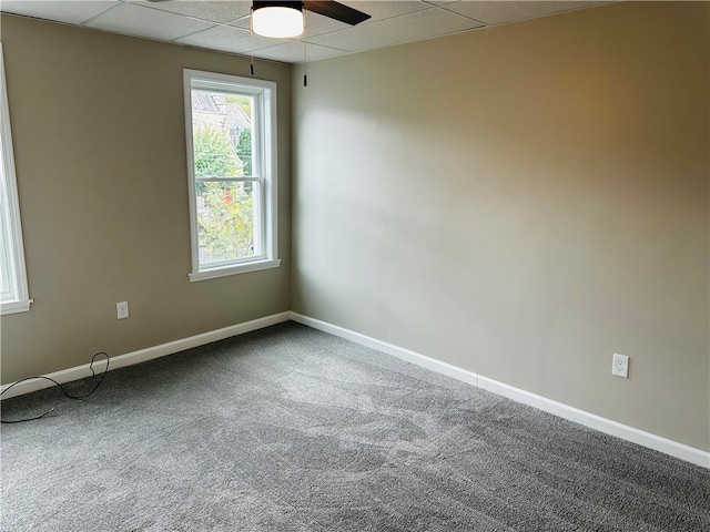 carpeted empty room with a paneled ceiling and ceiling fan