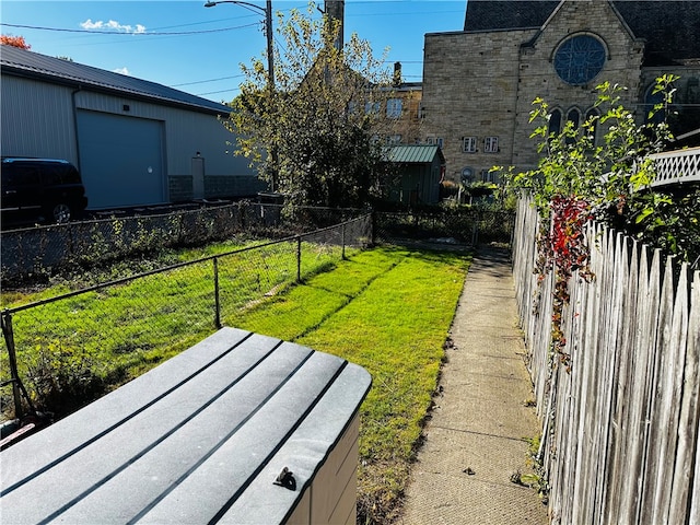 view of yard featuring a garage and an outbuilding