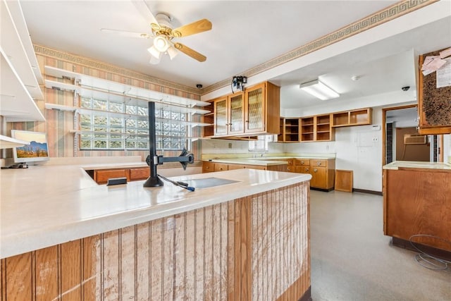 1565 State Route 31, East Huntingdon, PA 15666 - kitchen with brown cabinetry, open shelves, a ceiling fan, a sink, and glass insert cabinets