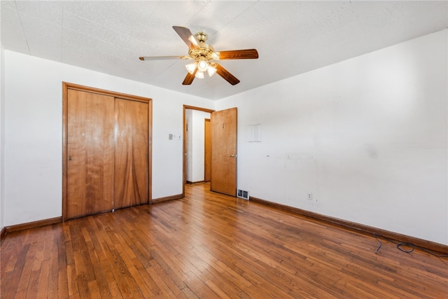 unfurnished bedroom with a closet, hardwood / wood-style floors, and ceiling fan