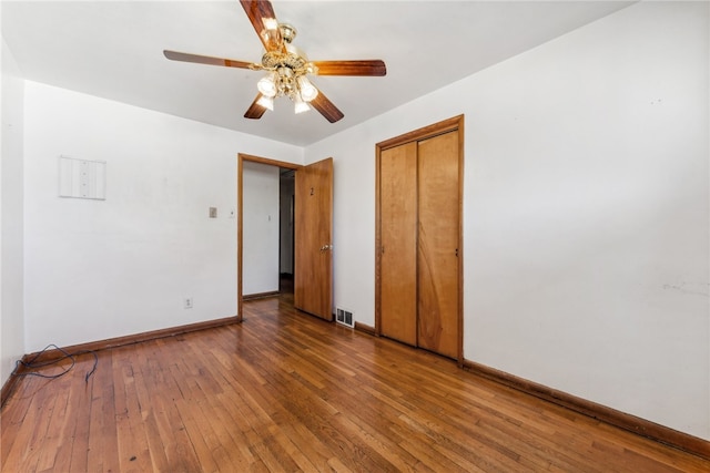 unfurnished bedroom with a closet, hardwood / wood-style floors, and ceiling fan