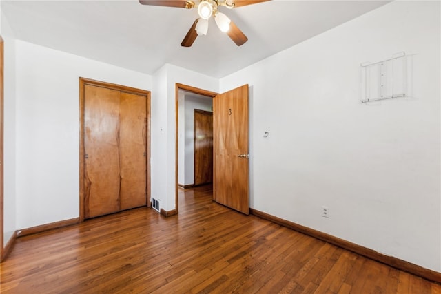 unfurnished bedroom featuring a closet, dark hardwood / wood-style flooring, and ceiling fan