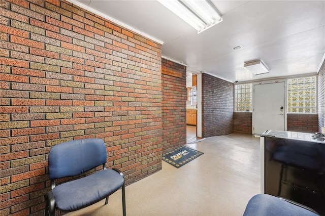 sitting room featuring brick wall