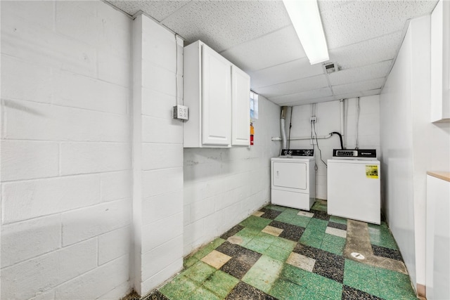 laundry room featuring washer and dryer and cabinets