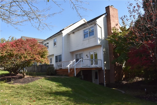 rear view of house with a yard and a deck