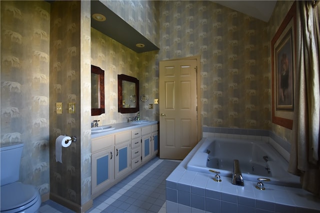 bathroom featuring tile patterned flooring, a relaxing tiled tub, vanity, and toilet