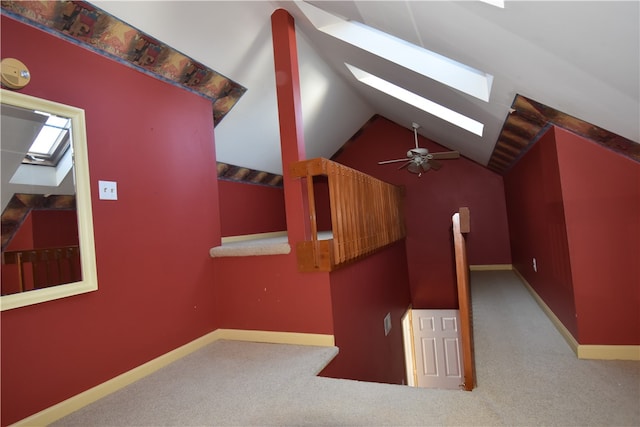 additional living space featuring ceiling fan, vaulted ceiling with skylight, and carpet flooring