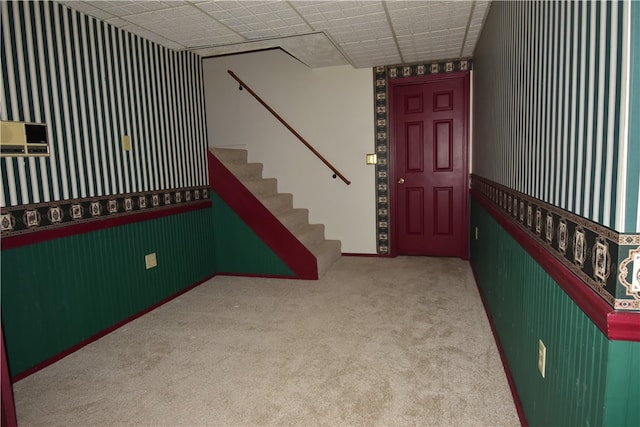 interior space featuring light carpet and a paneled ceiling