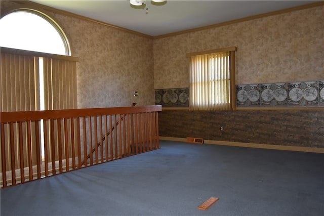 unfurnished room with ornamental molding and carpet