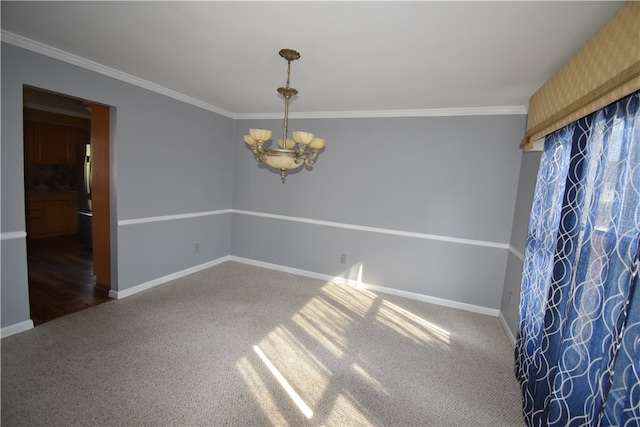 carpeted spare room with a notable chandelier and ornamental molding