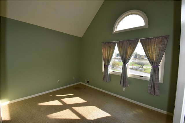 carpeted empty room featuring high vaulted ceiling and a healthy amount of sunlight