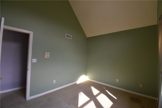 empty room featuring carpet and high vaulted ceiling