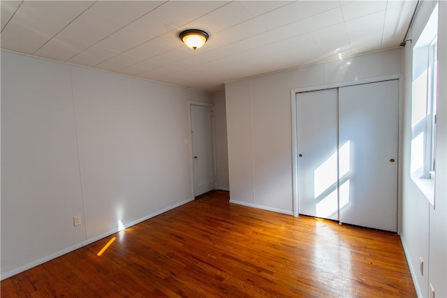 unfurnished bedroom with wood-type flooring and a closet