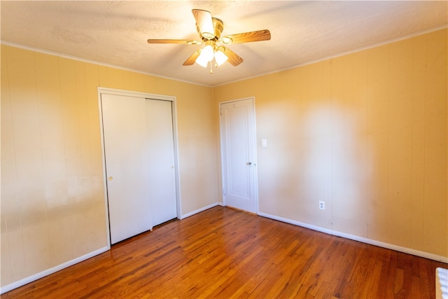 unfurnished bedroom with ornamental molding, hardwood / wood-style flooring, and ceiling fan