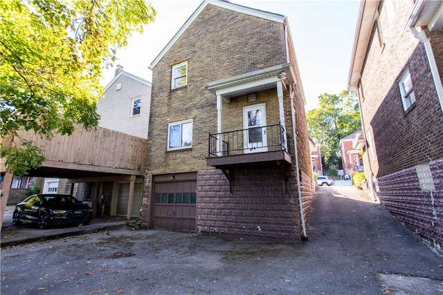 back of house with a balcony and a garage