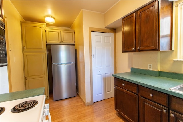 kitchen with light hardwood / wood-style flooring, stainless steel fridge, and white electric stove